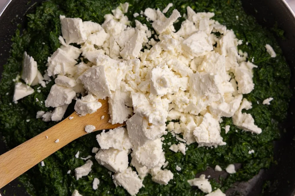 Adding crumbled feta to spinach