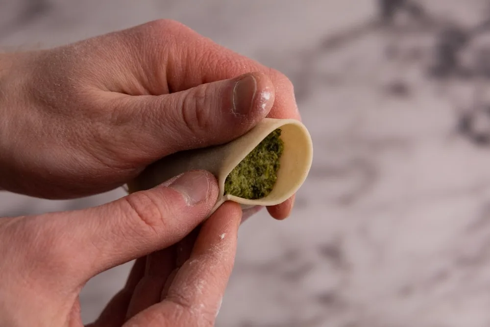 Forming spinach pierogi with hands
