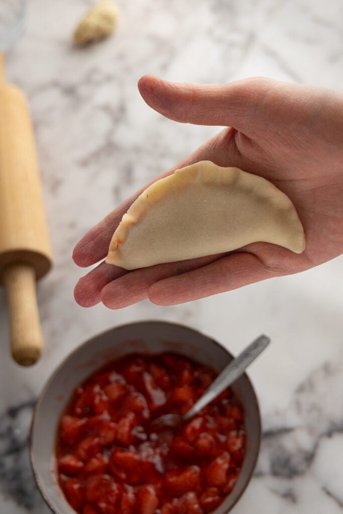 Hand formed pierogi with strawberry sauce filling