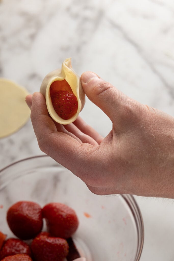 Prepping pierogi with whole strawberries
