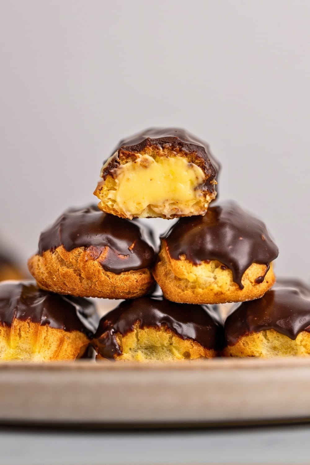 Chocolate eclairs stacked on a plate