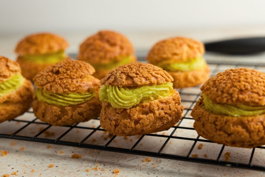 Creamy streusel topped puffs with pistachio pastry cream