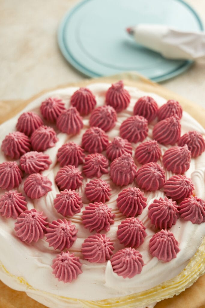 Meringue cake topped with raspberry pastry cream




