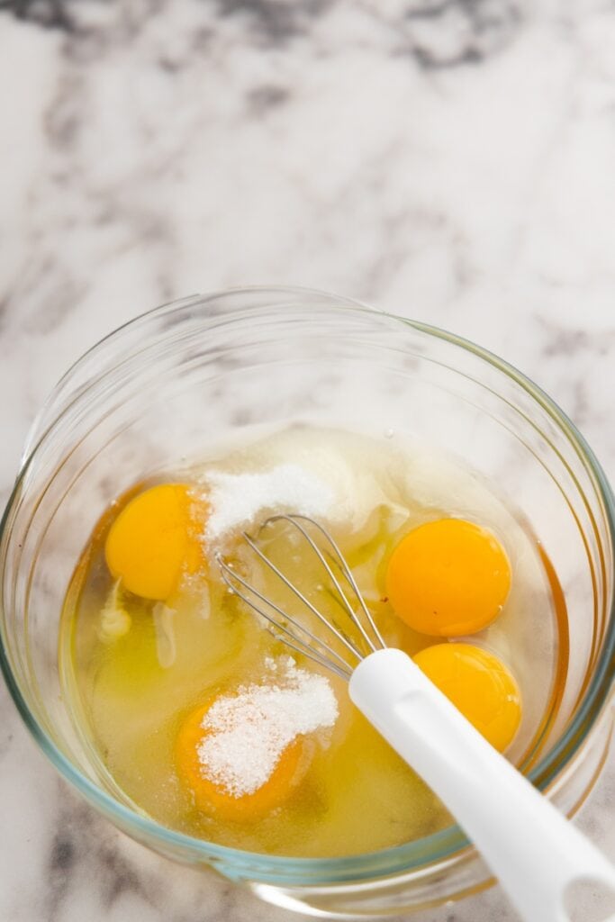Adding the egg and sugar in a bowl