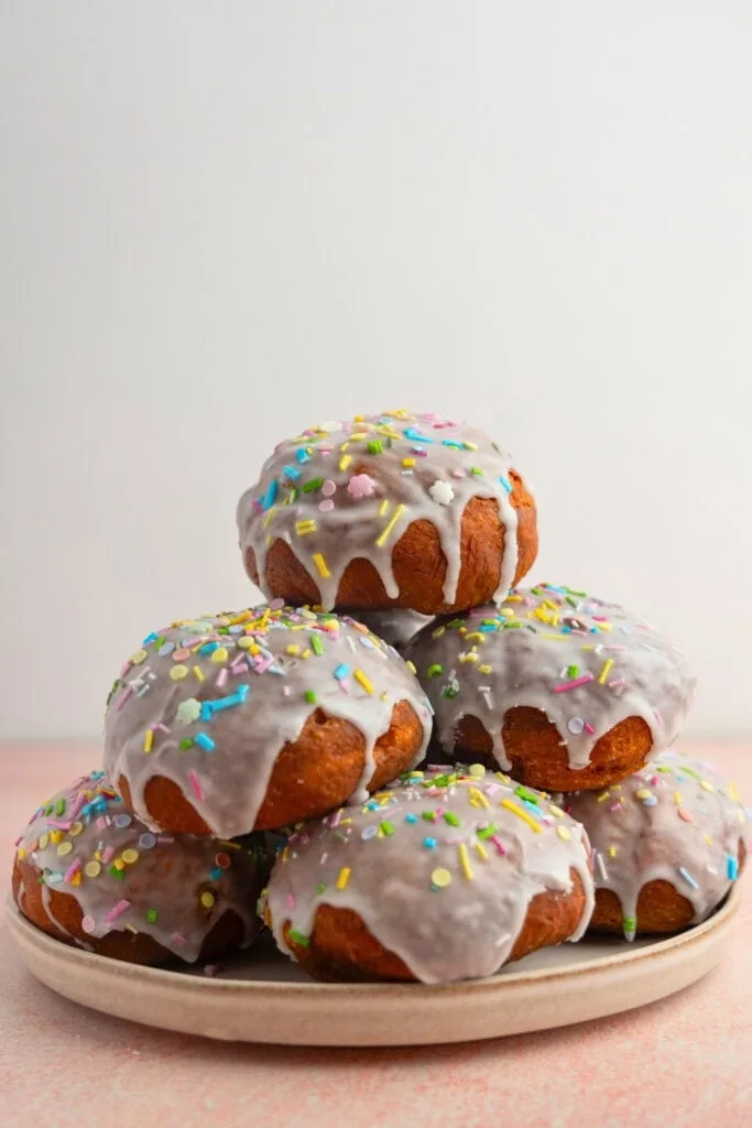 Glazed paczki with vanilla cream filling and sprinkles