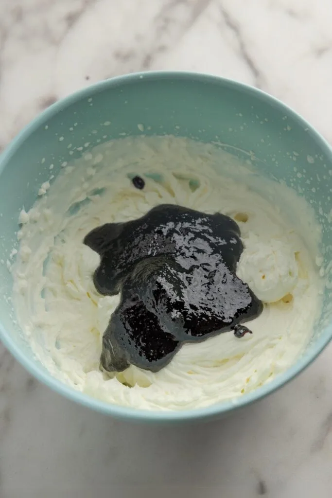 Adding blueberry sauce to the cream