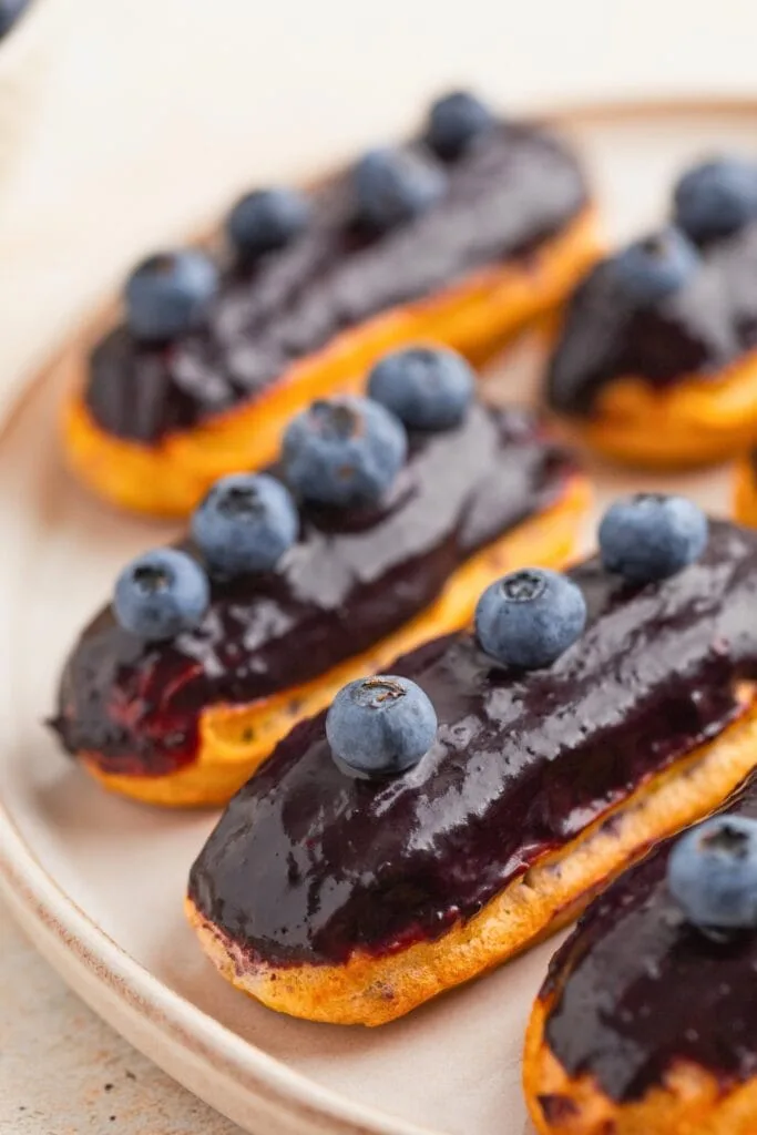 Rich ganache-topped eclairs with blueberry mascarpone