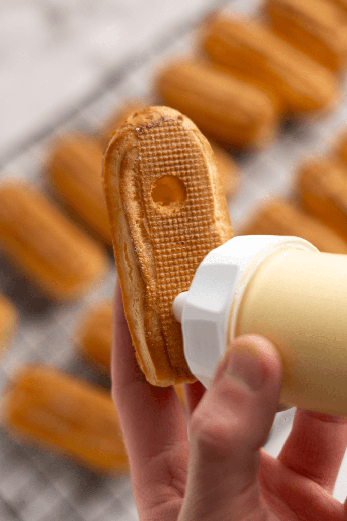Filling the eclair with pastry cream