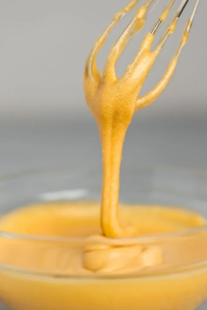 Smooth and thick coffee glaze dripping from a whisk