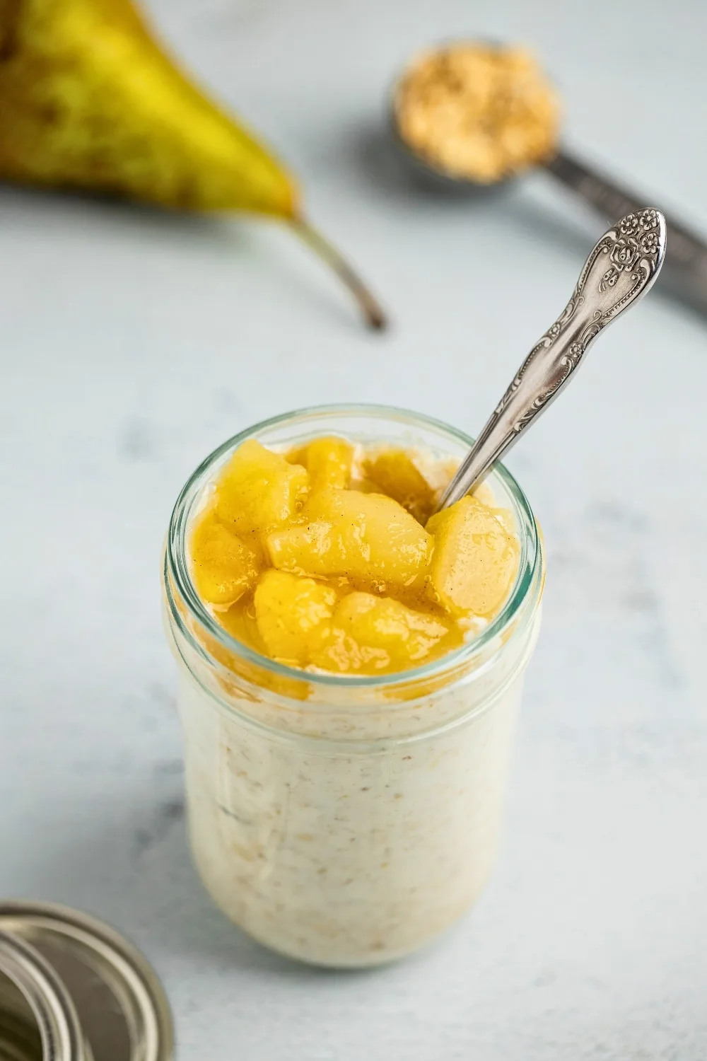 Pear overnight oats jar with a spoon