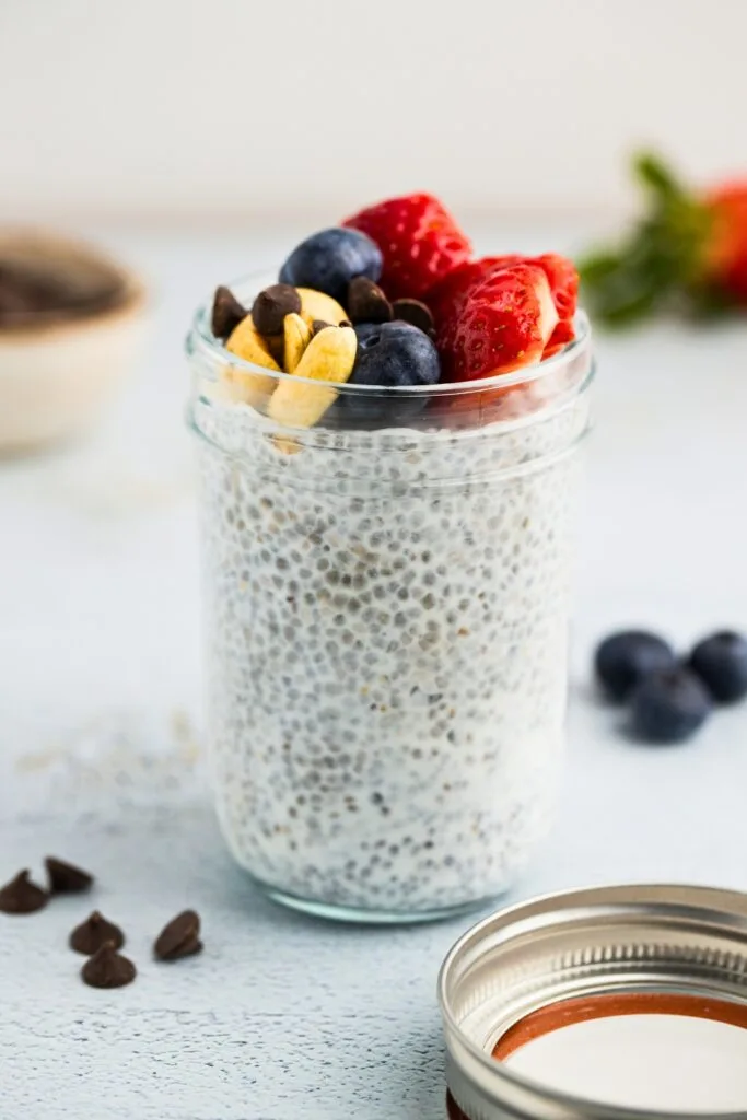 Healthy greek yogurt chia pudding in a jar with fruits and nuts