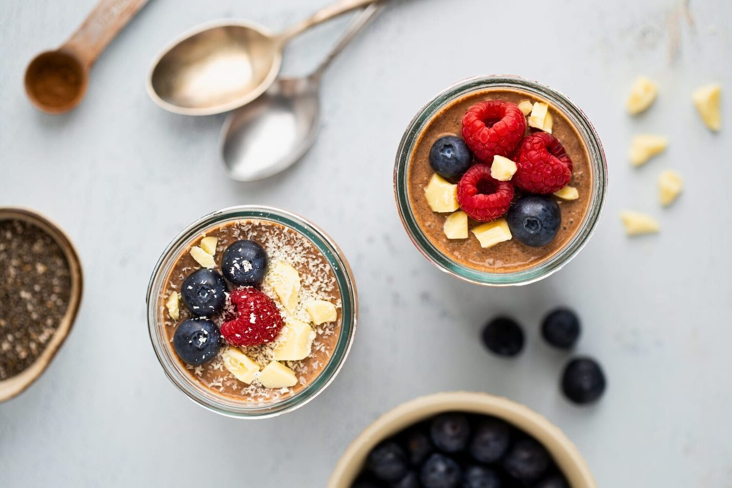 Chocolate chia pudding topped with fresh berries, white chocolate, and desiccated coconut