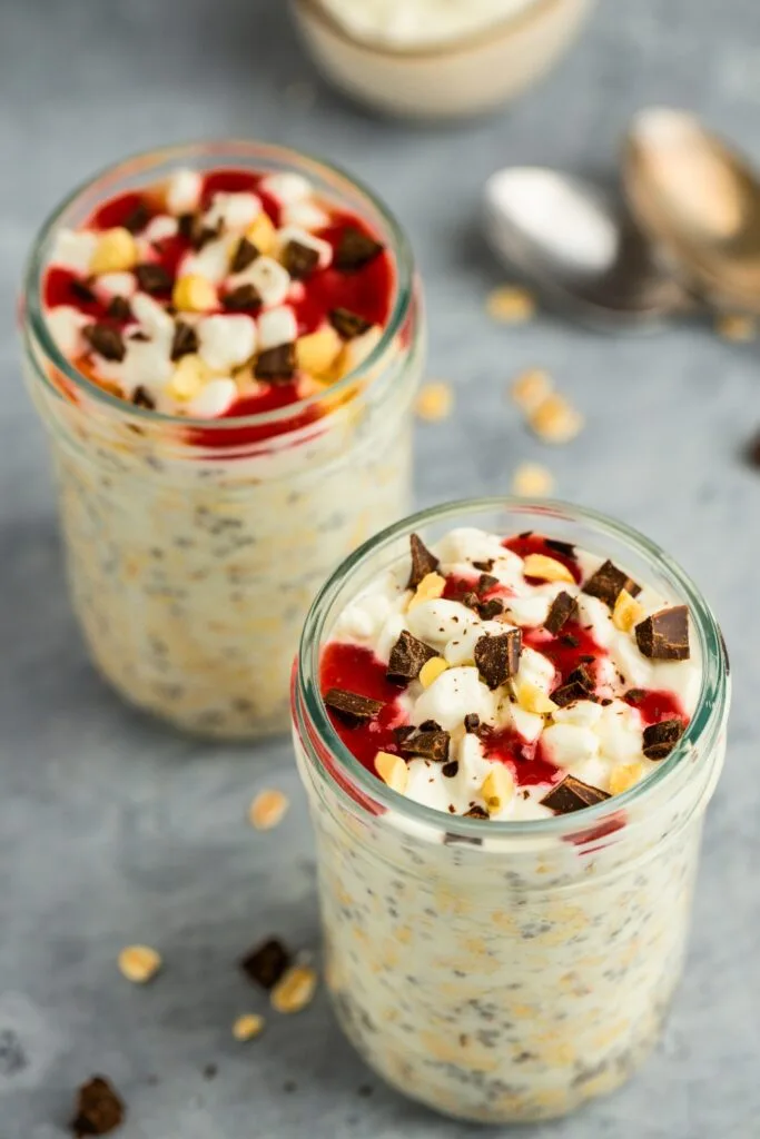 Cottage cheese overnight oats topped with chopped dark chocolate chopped peanuts and strawberry puree
