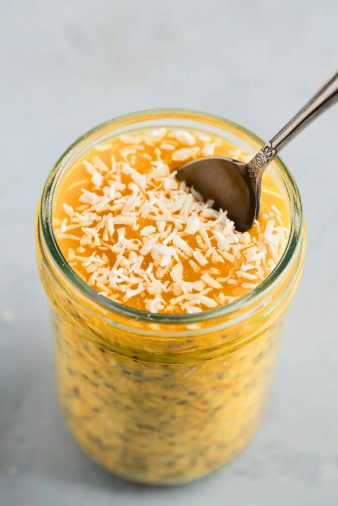 Creamy mango flavored overnight oats in a breakfast jar