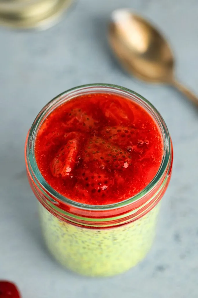 A jar of matcha chia pudding perfectly layered with strawberry compote