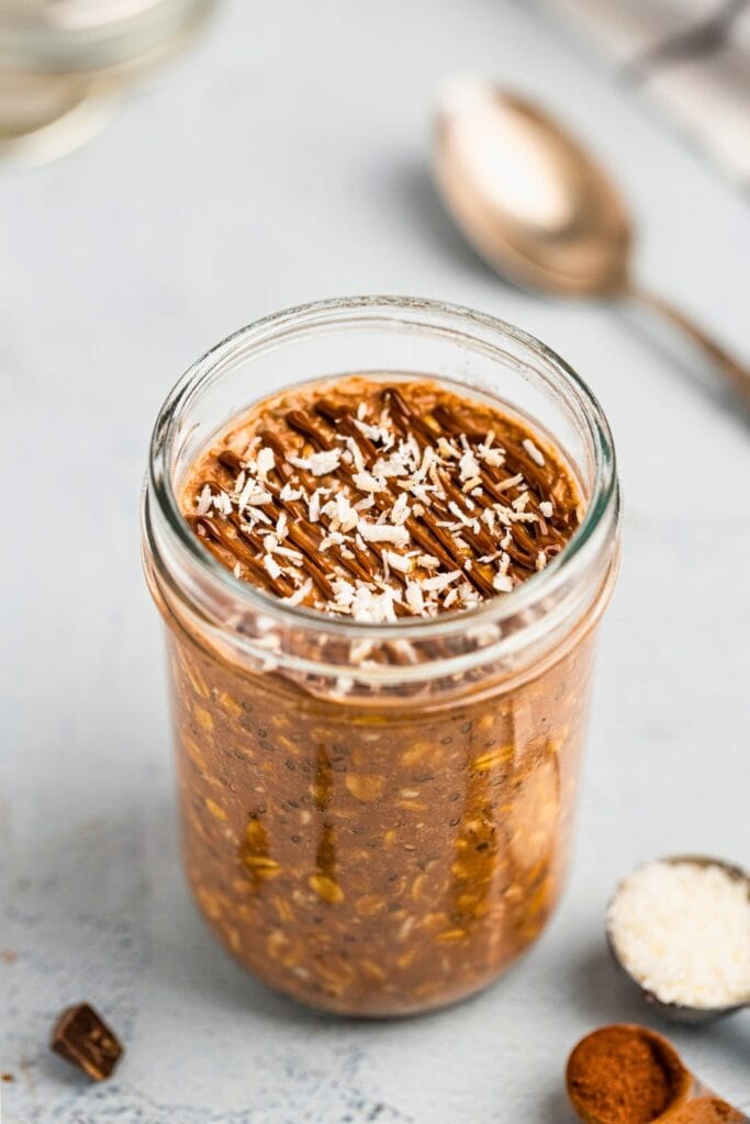 Rich coconut chocolate overnight oats with ganache and shredded coconut topping
