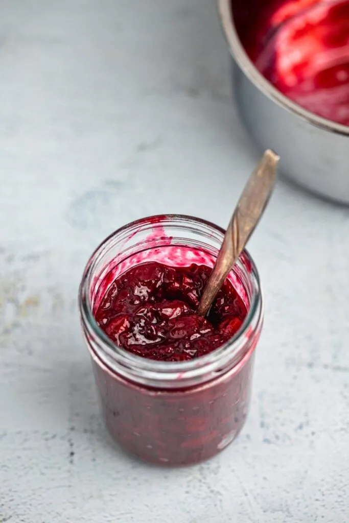 Cherry compote: jar with a spoon