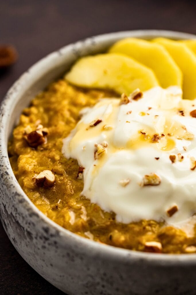 Pumpkin oatmeal closeup: oatmeal, yogurt, apple slices & pecans