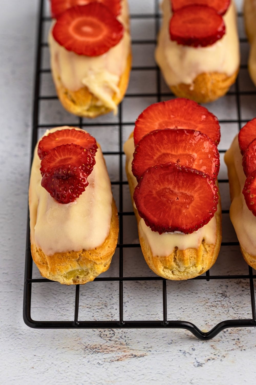 Strawberry eclairs on a cooling rack