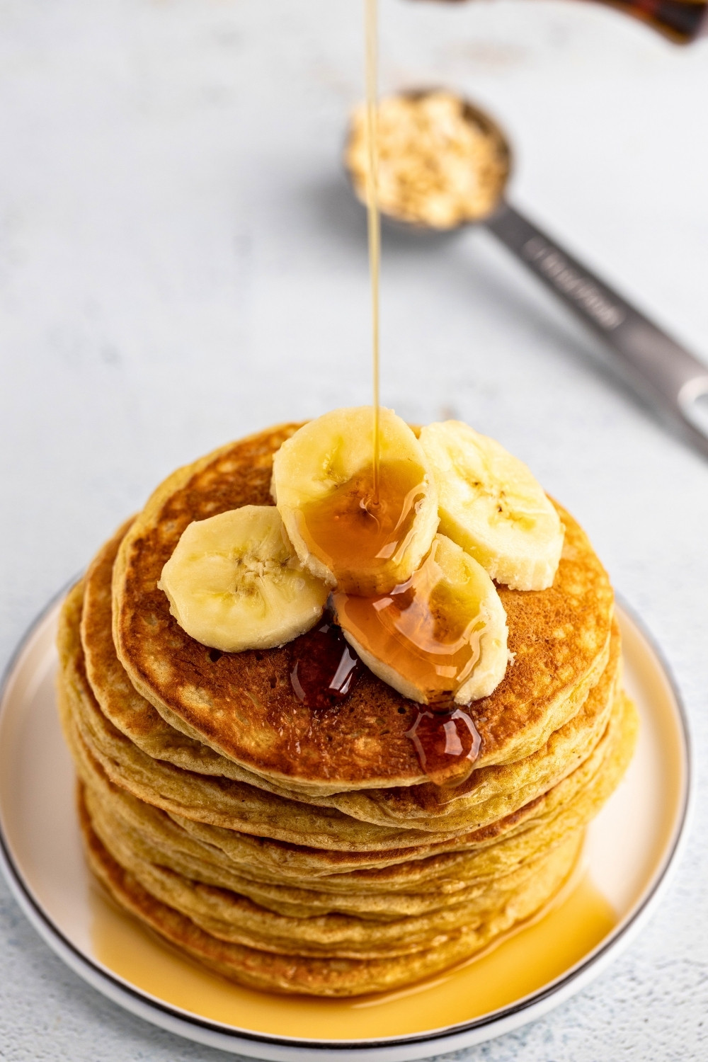 Cottage cheese oats pancakes pouring maple from angle