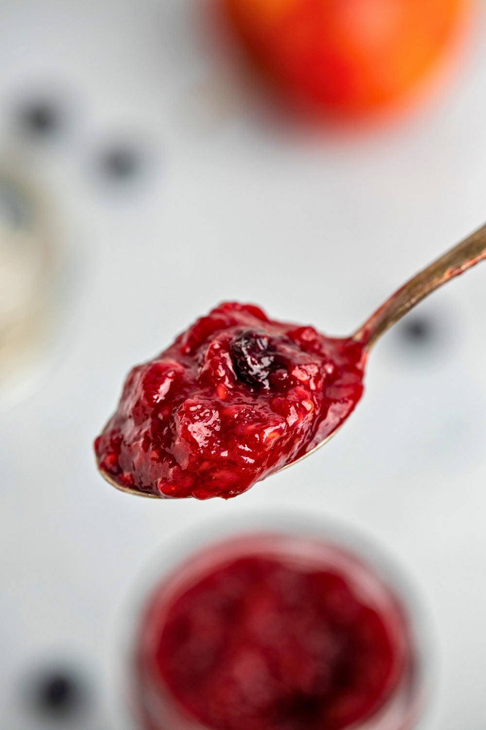 Apple mixed berries compote on a spoon